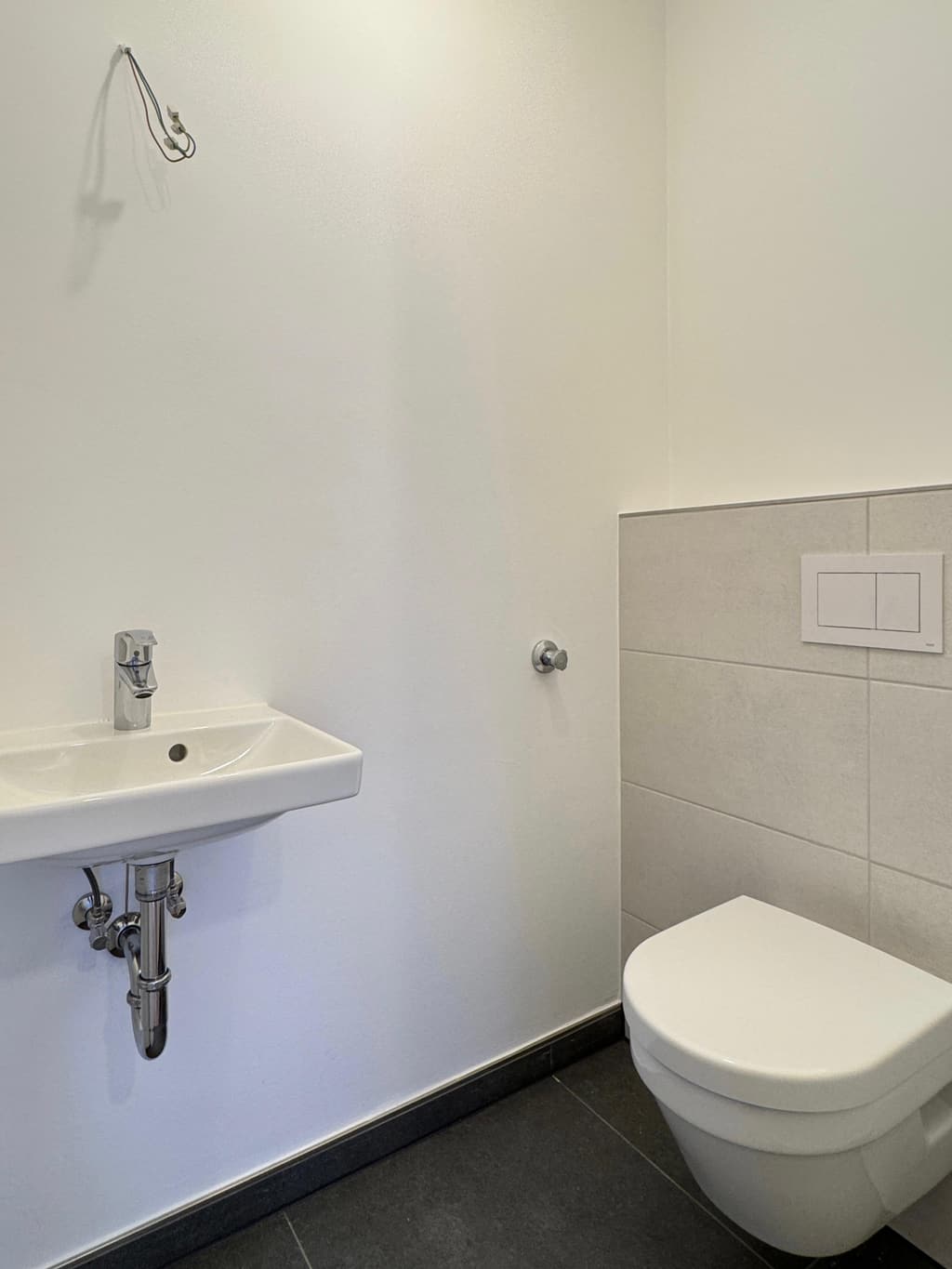 Gefliestes Bad mit WC und Waschtisch – Arbeit von Jörg Potthoff